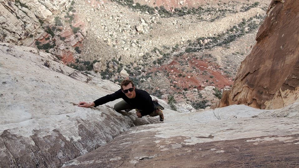 Caleb, before the accident, high on a pale sandstone slab at Red Rock with the valley far below
